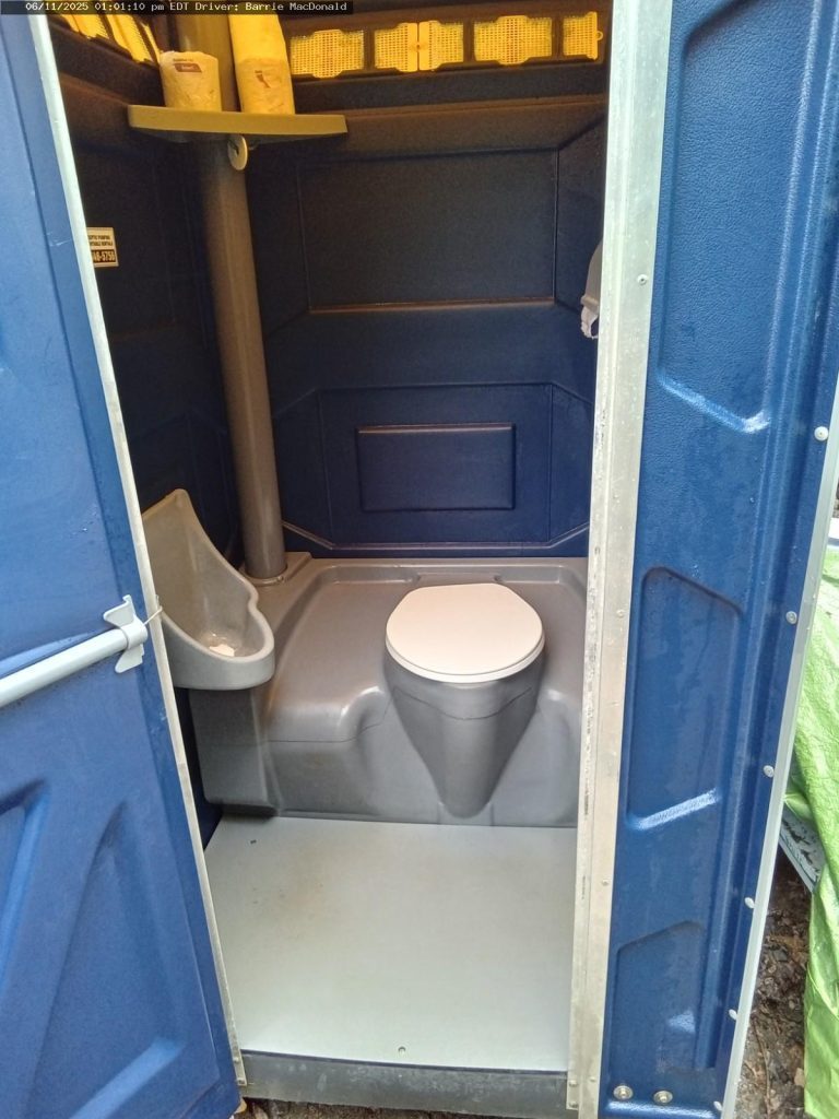 Interior of a blue portable toilet with urinal attachments