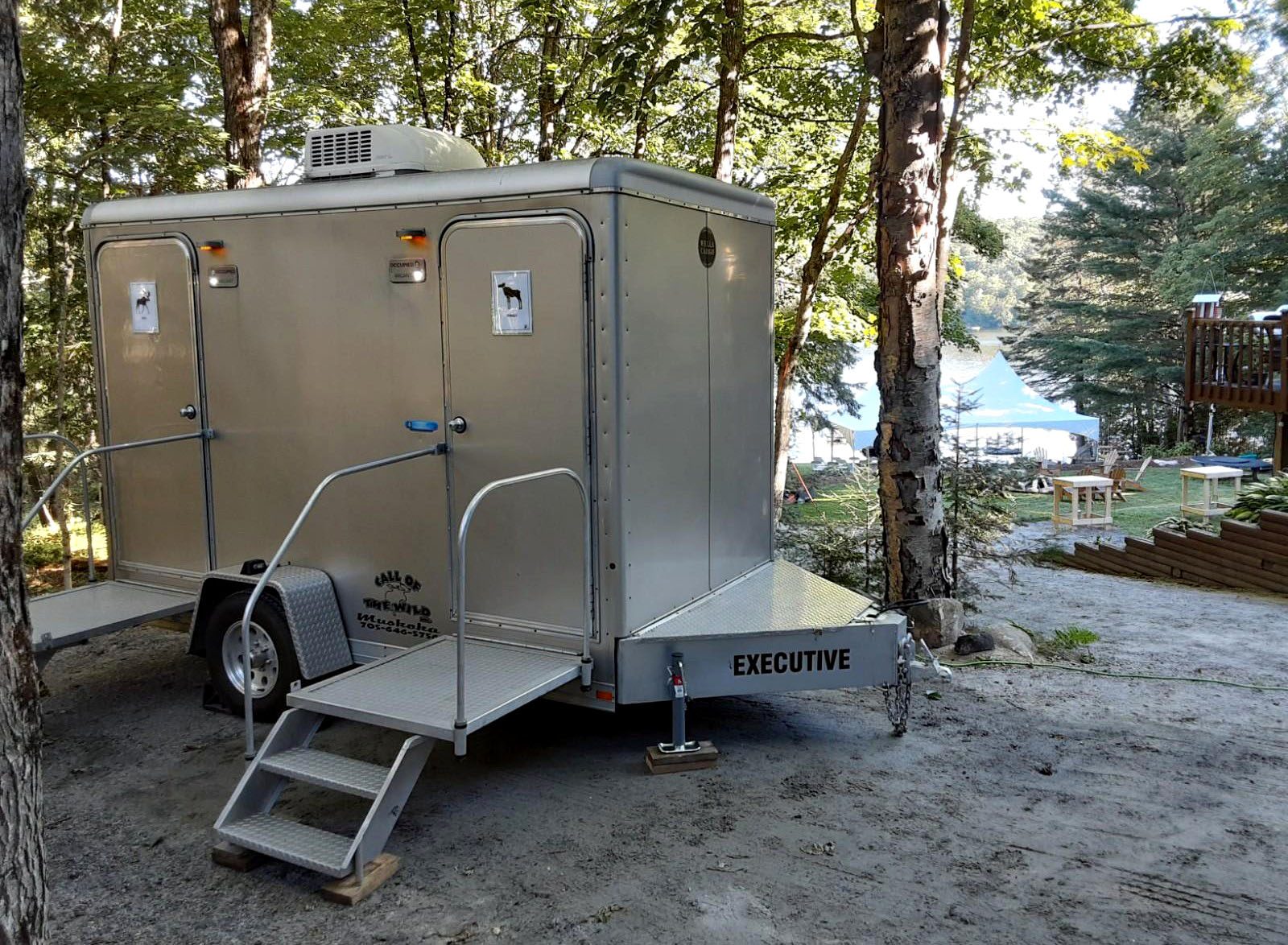 Luxury portable restroom trailer in a forest campground setting