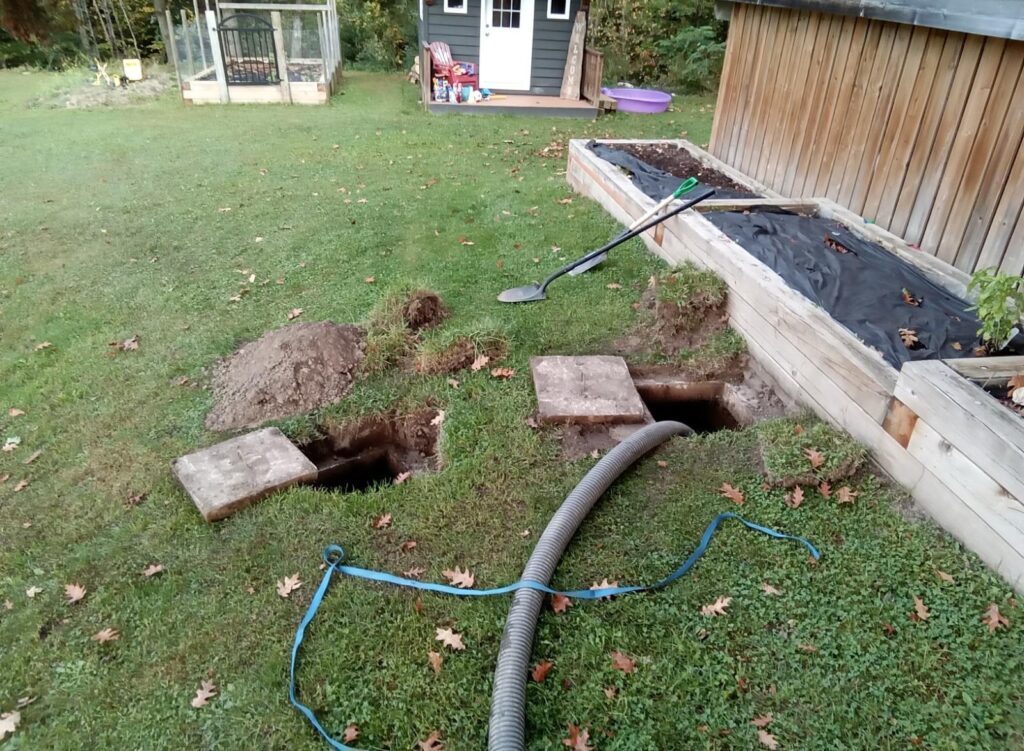 Outdoor landscaping prep for drain installation near garden bed