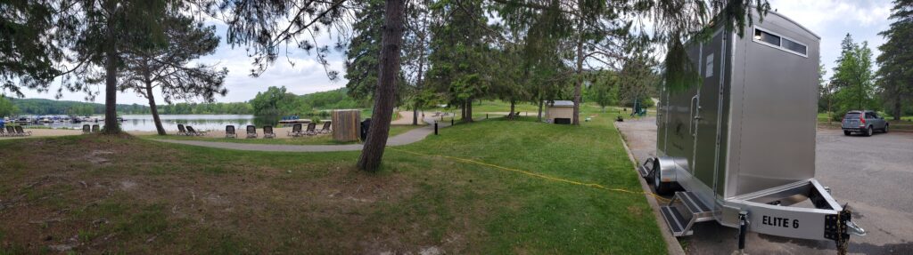 Park setting with portable restroom trailer near a lake