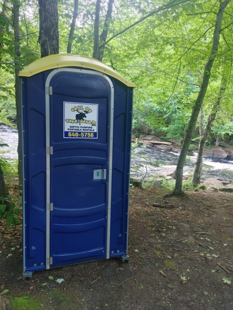 Portable toilet by a forest river in New Brunswick