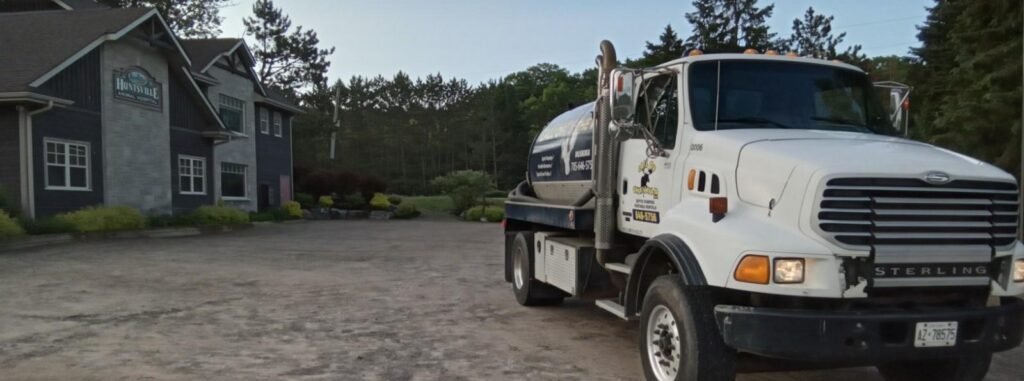 Septic service truck parked outside Mainline Mechanical building